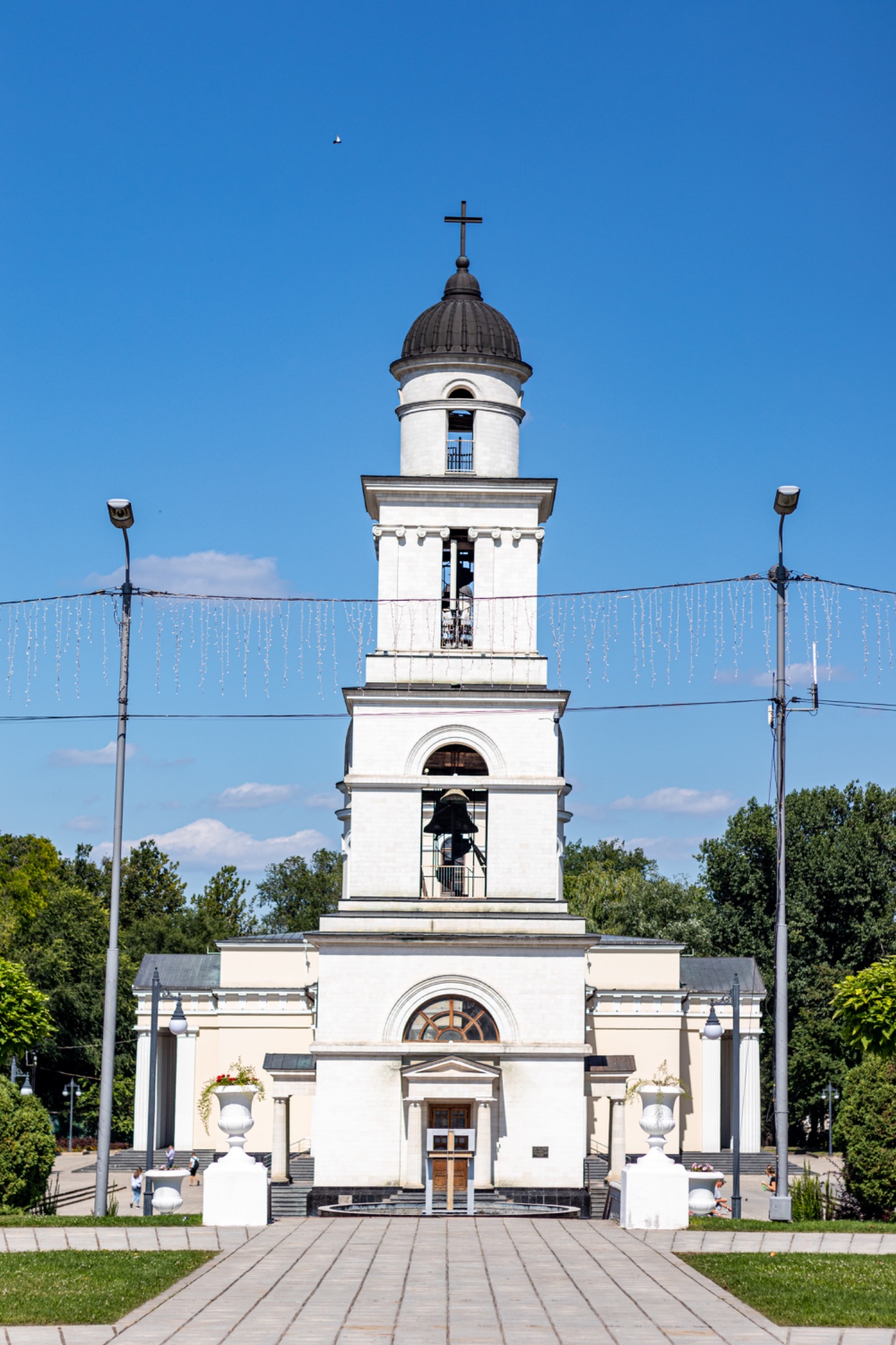 White church with bell tower under blue sky in Chisinau, Moldova.