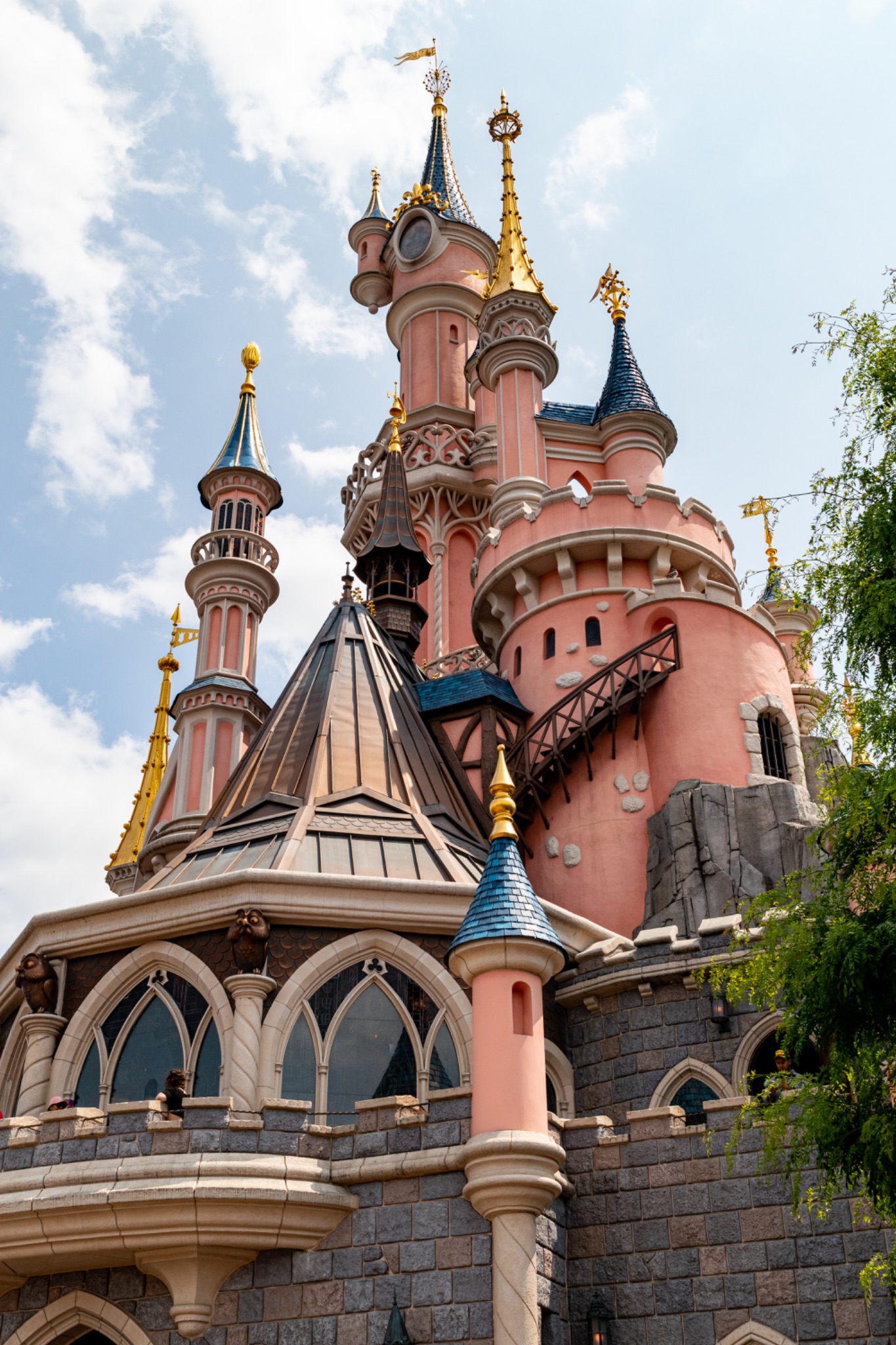 Pink Castle Exterior with Turrets and Stone Base at Disneyland Paris.