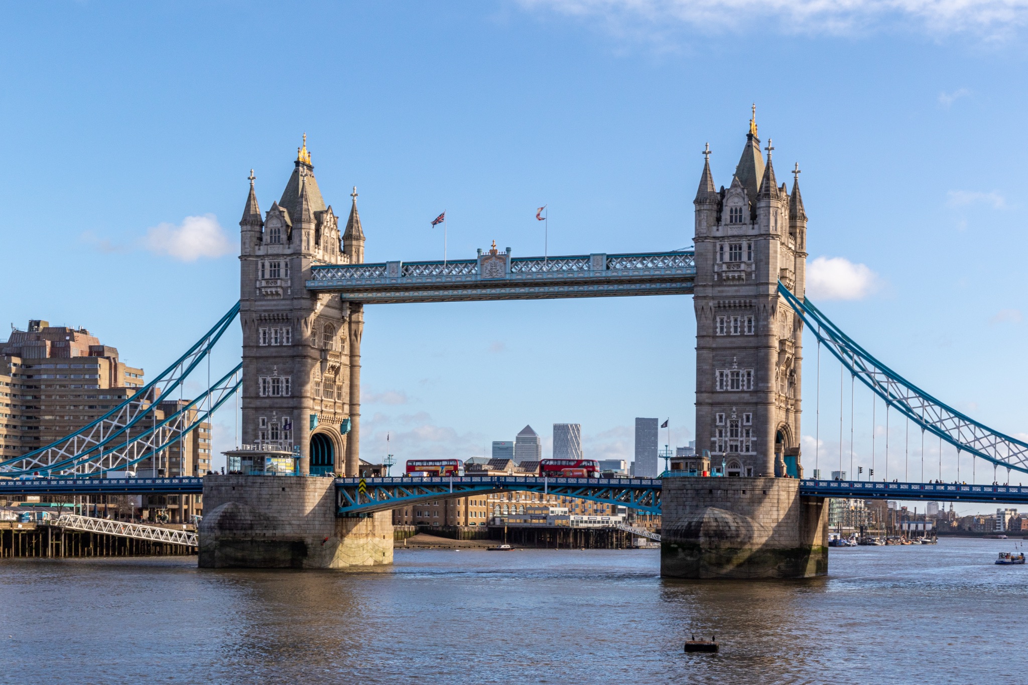 London's iconic Tower Bridge against a clear blue sky, with city buildings in the background.