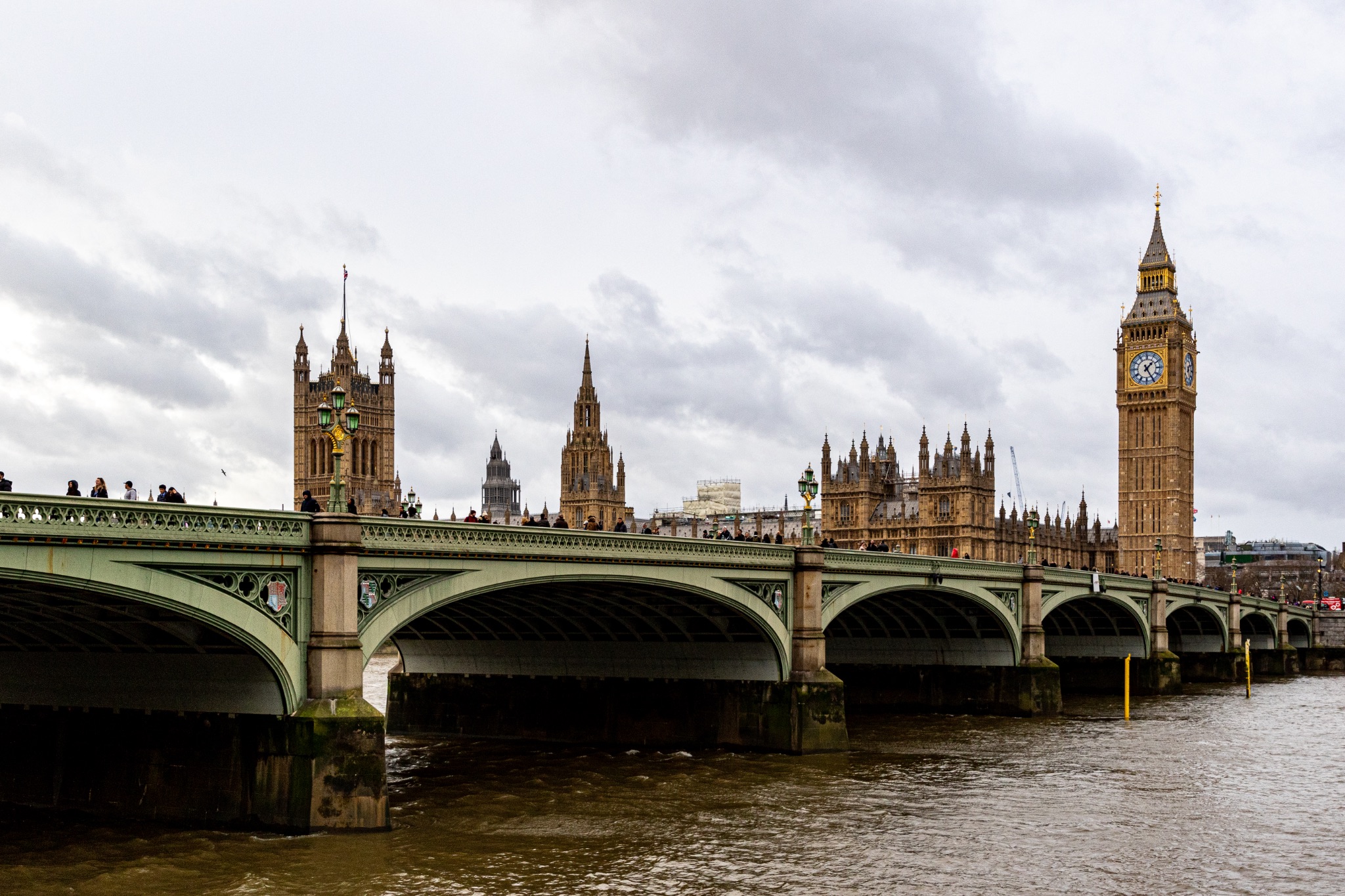 Westminster Bridge and the iconic Big Ben on a cloudy day in London, UK.