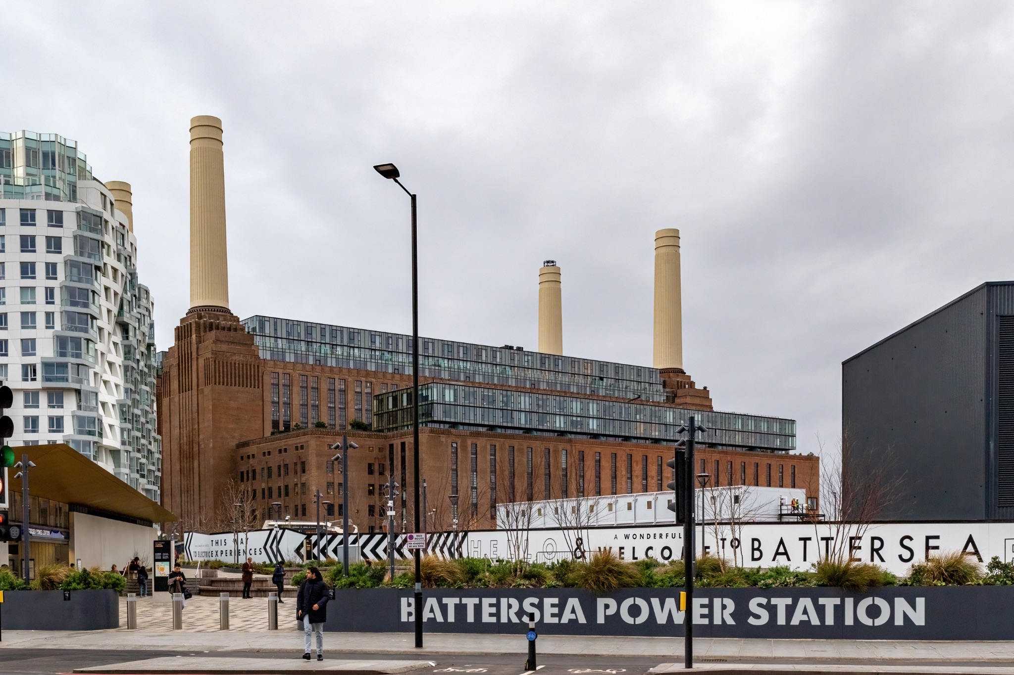 Battersea Power Station in London on a cloudy day, iconic landmark with modern buildings around.