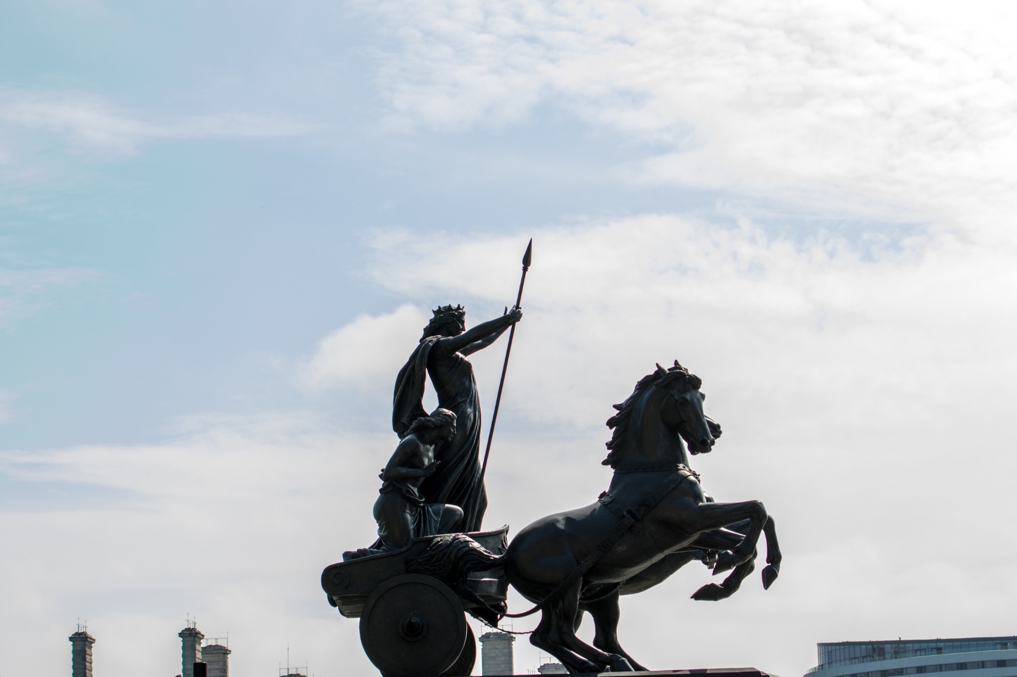 Silhouette of a warrior statue on horseback against a cloudy sky.