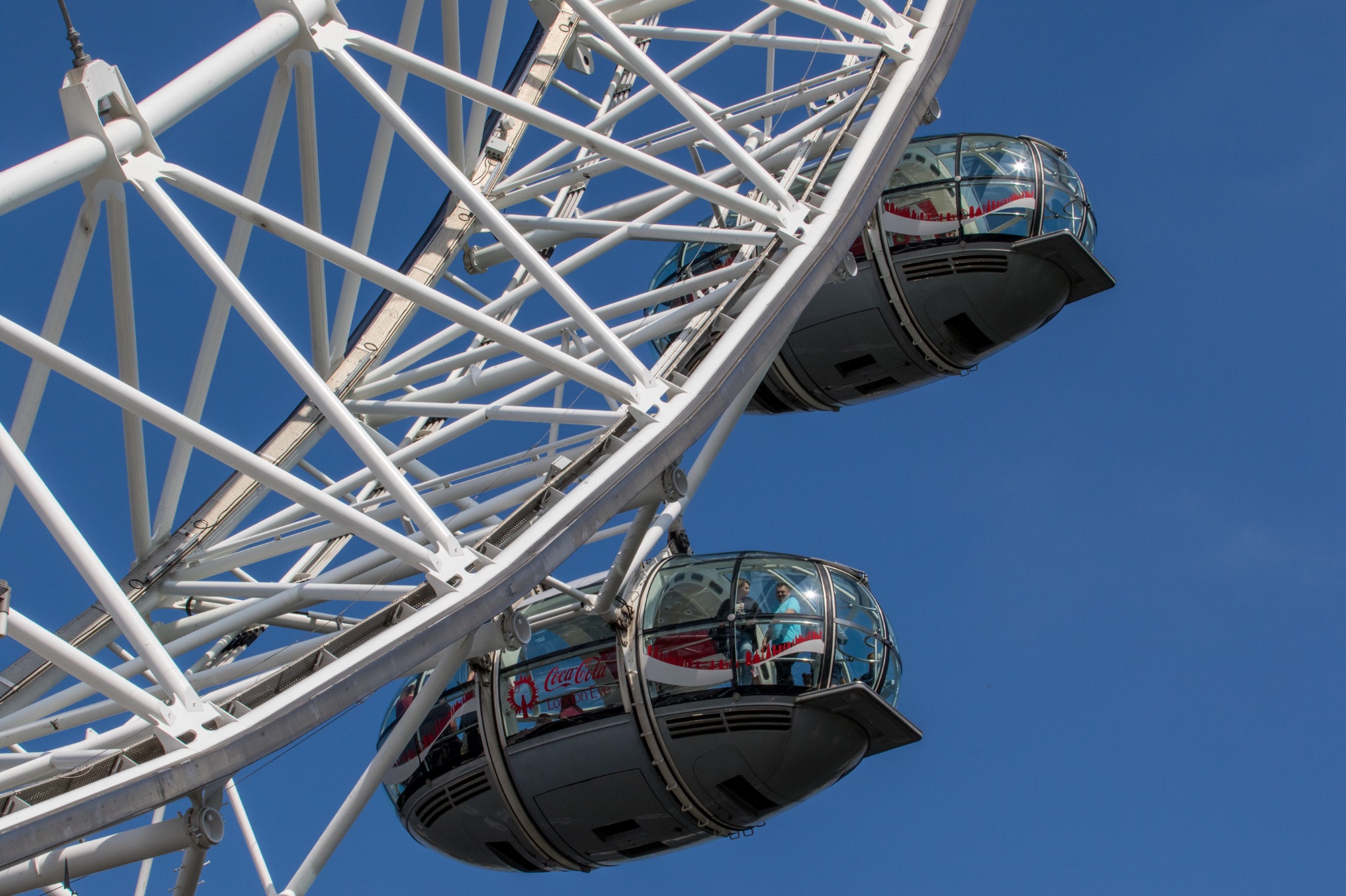 Close-up of a Ferris wheel with blue sky background.