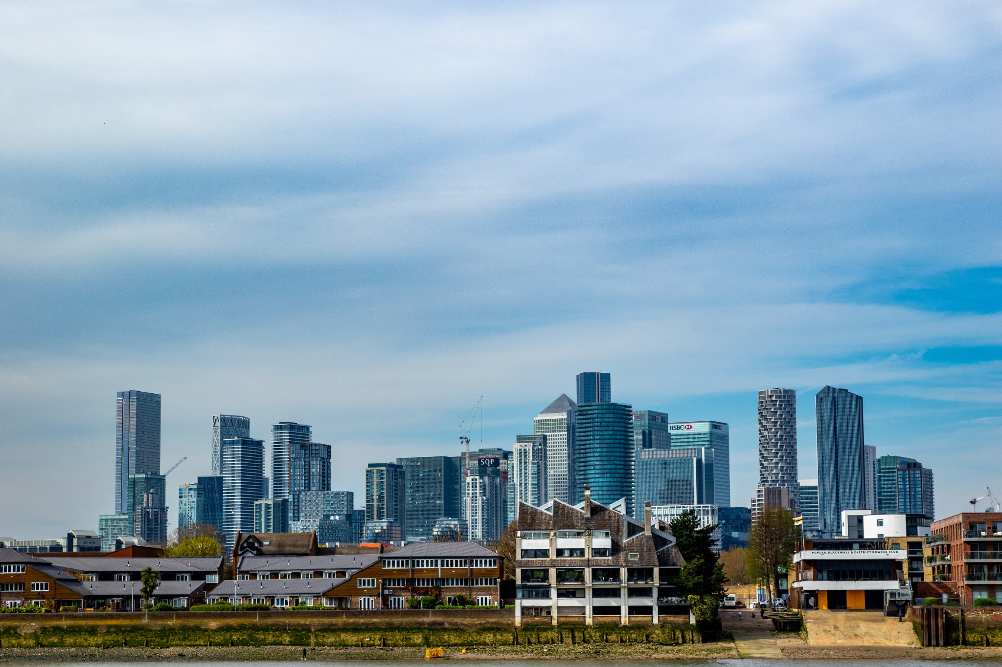 Modern city skyline with skyscrapers under blue sky with clouds, urban architecture background.