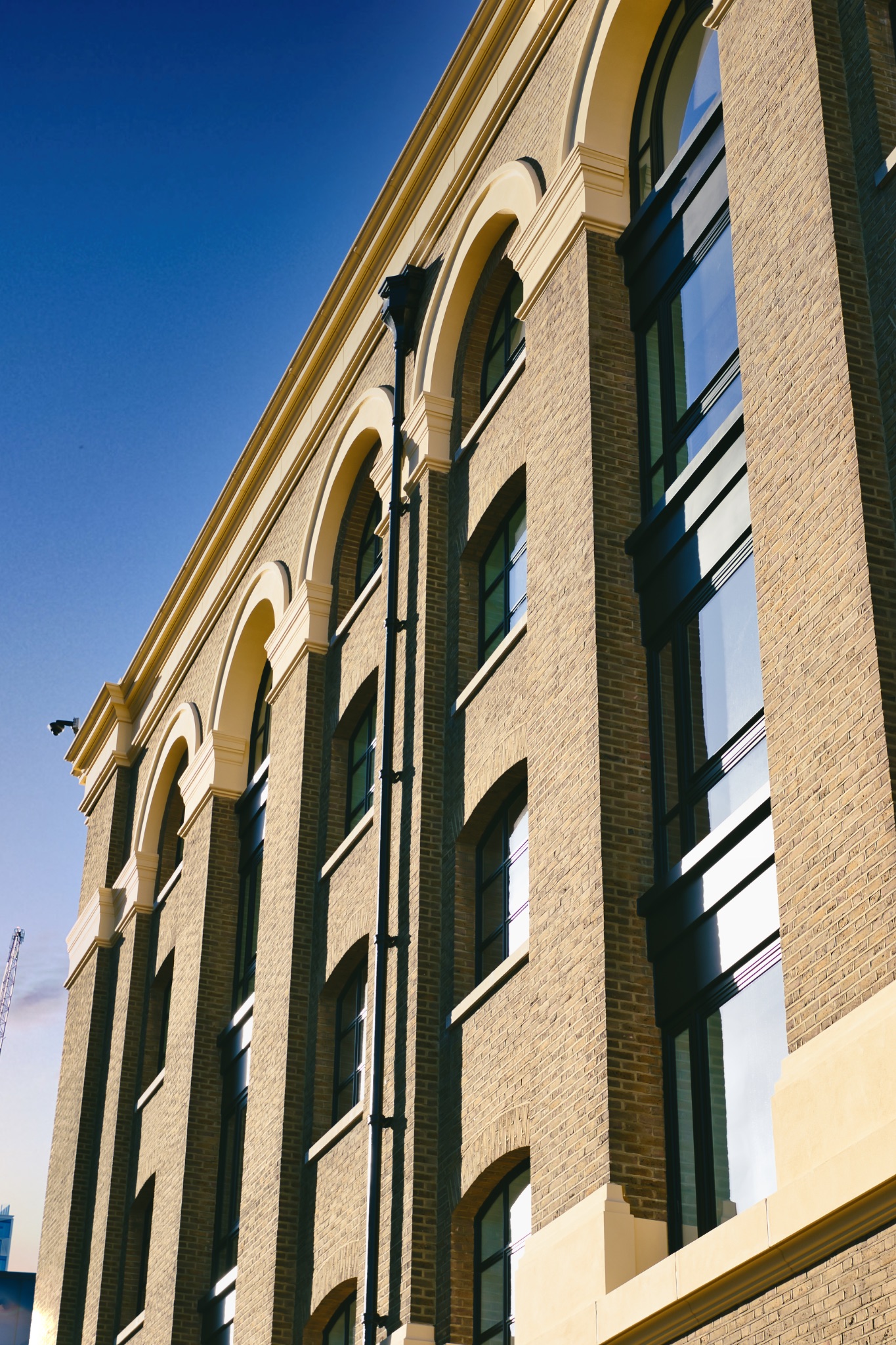 Multi-Story Brick Building with Arched Windows and Stone Facade in London, UK.