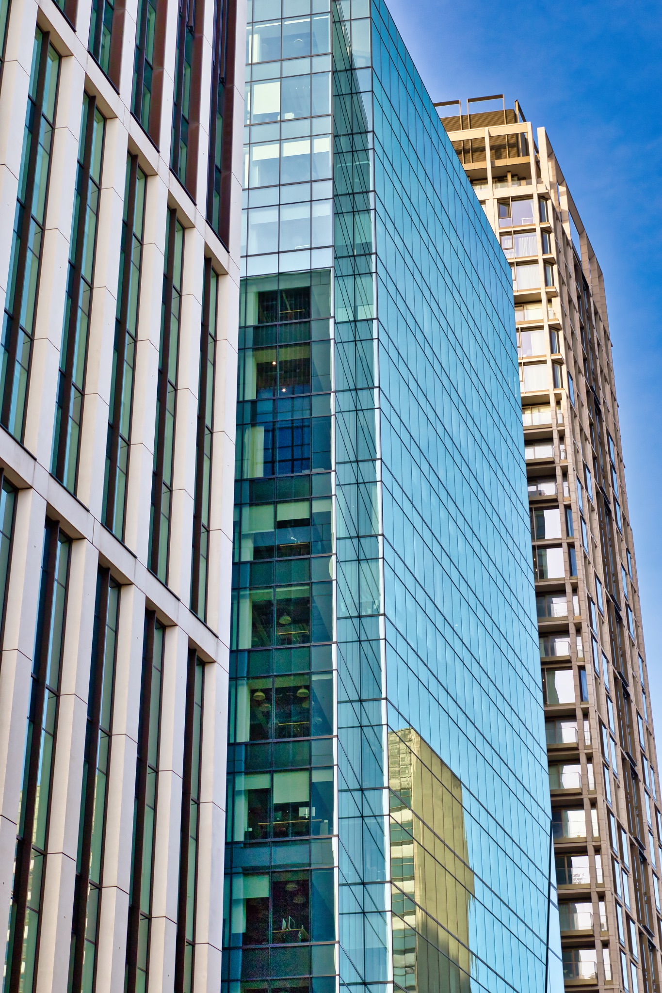 Three Modern Buildings with Glass, Concrete, and Metal Facades in London, UK.