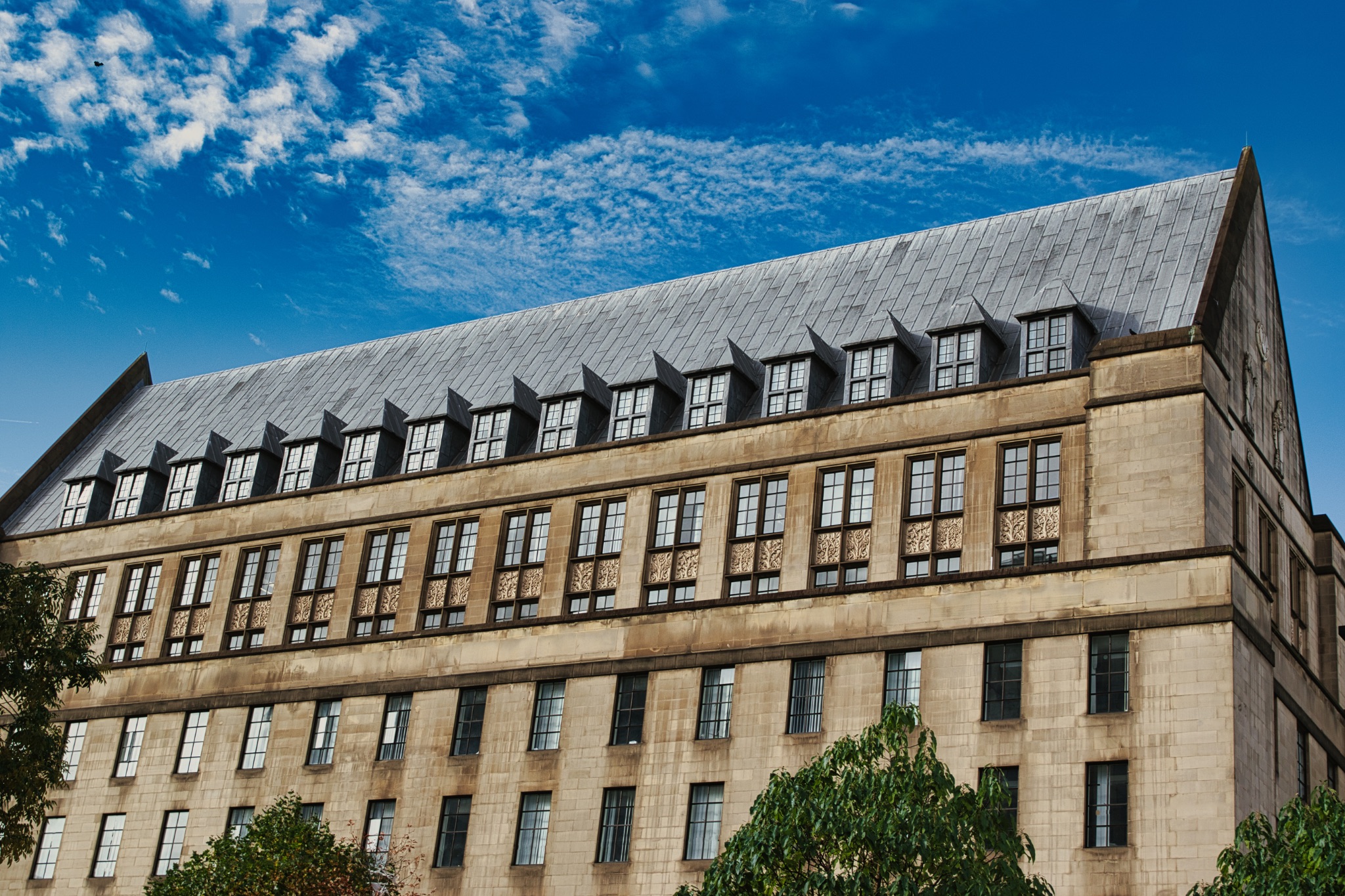 Beige Building with Many Windows and a Dark Gray Roof in Manchester, UK.
