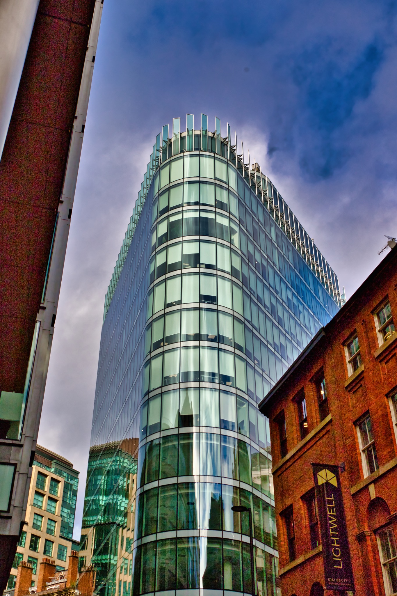 Modern Glass Skyscraper and Adjacent Brick Building in Manchester, UK