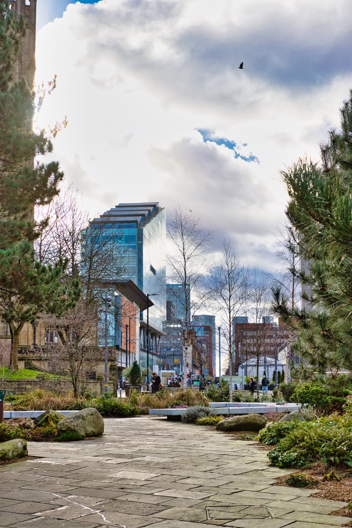 City Park Pathway with Modern and Historic Buildings in Manchester, UK.
