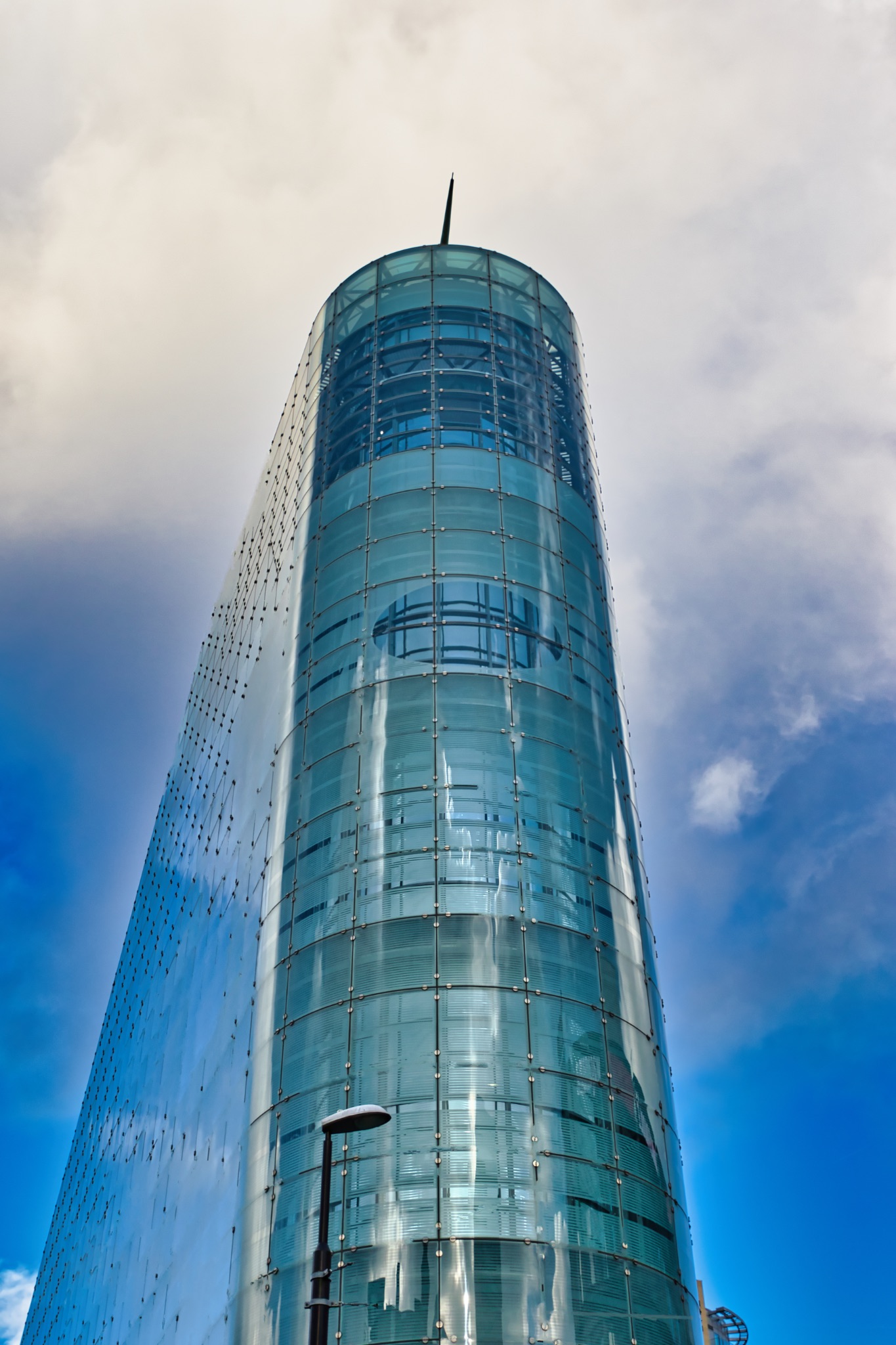 Modern Glass Building with Cylindrical Tower Section in Manchester, UK.