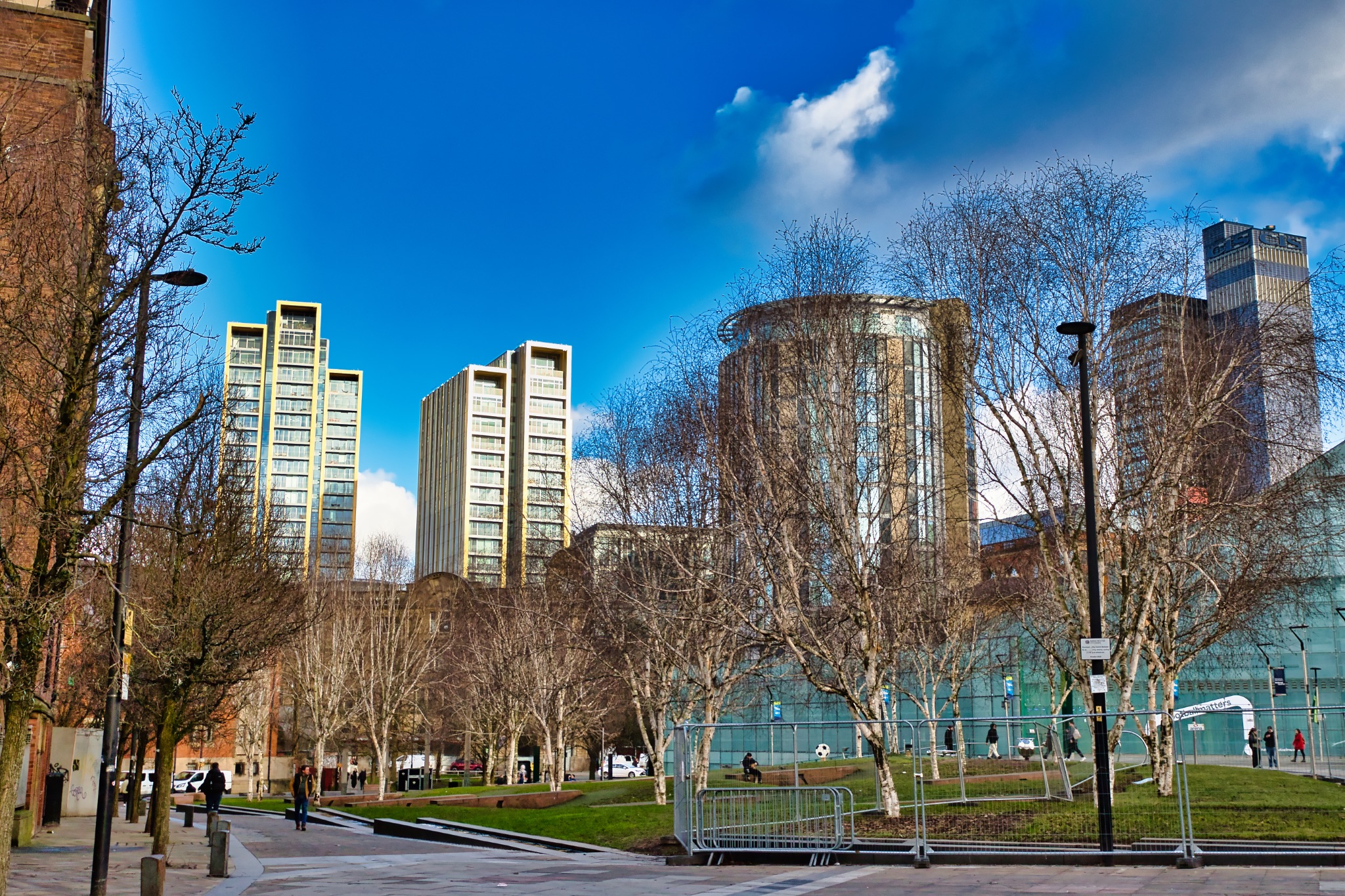 Urban Park with Modern High-Rise Buildings and Bare Trees in Manchester, UK.
