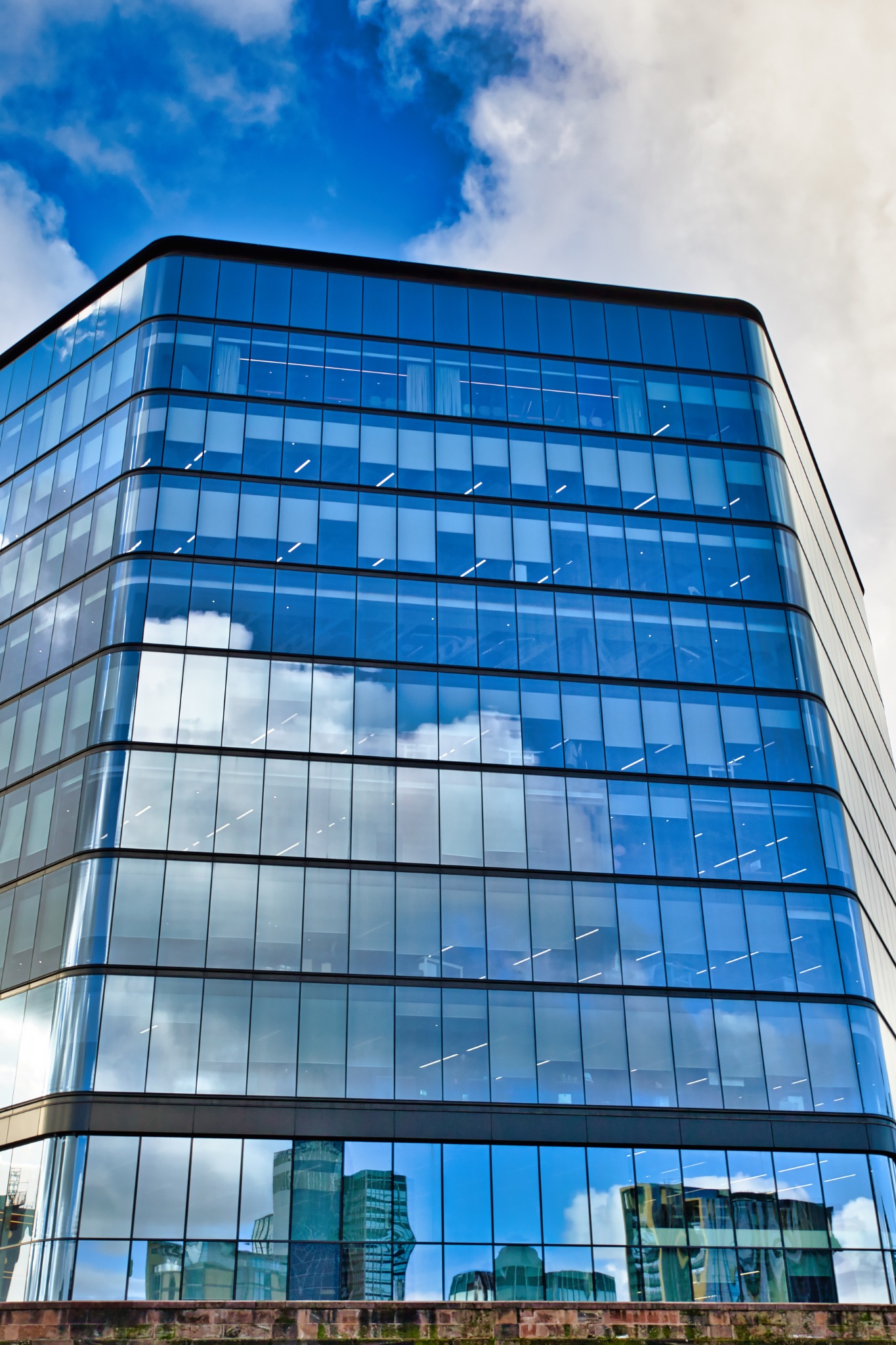 Glass Office Building with Cloud Reflections in Manchester, UK.