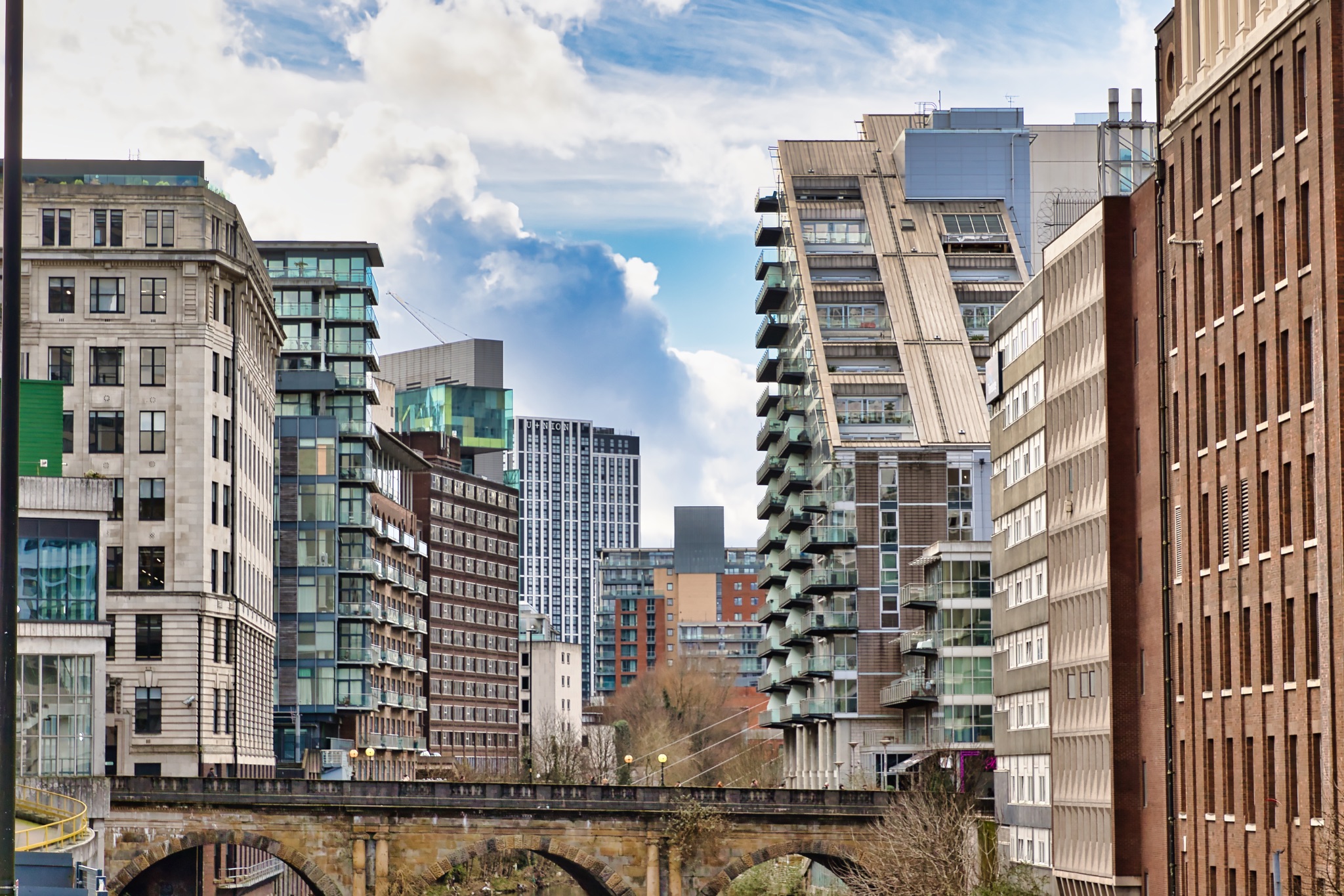 Urban Skyline with Modern and Historic Buildings near a Bridge in Manchester, UK.