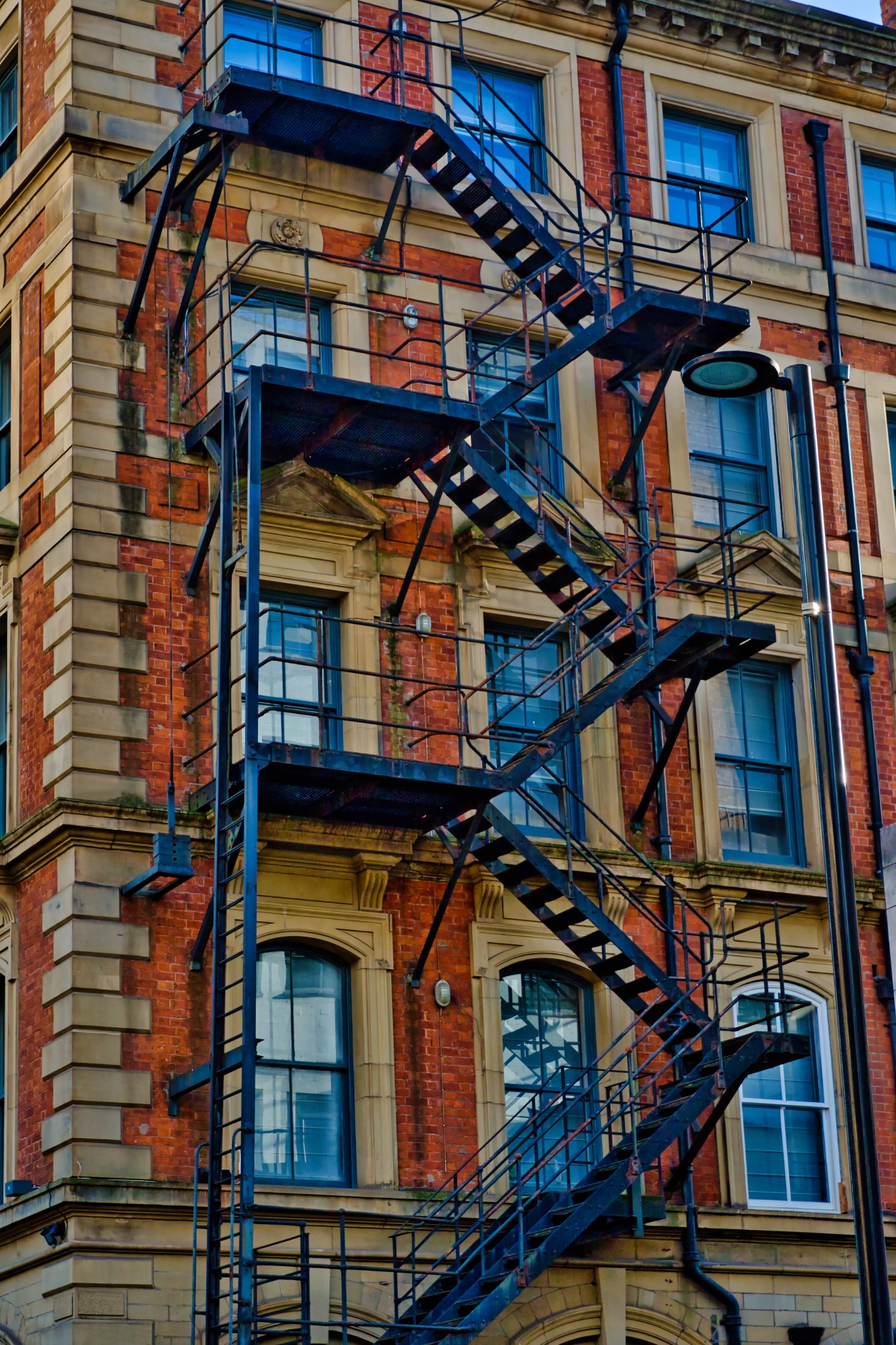 Multi-Story Brick Building with Interconnected Fire Escapes in Manchester, UK.