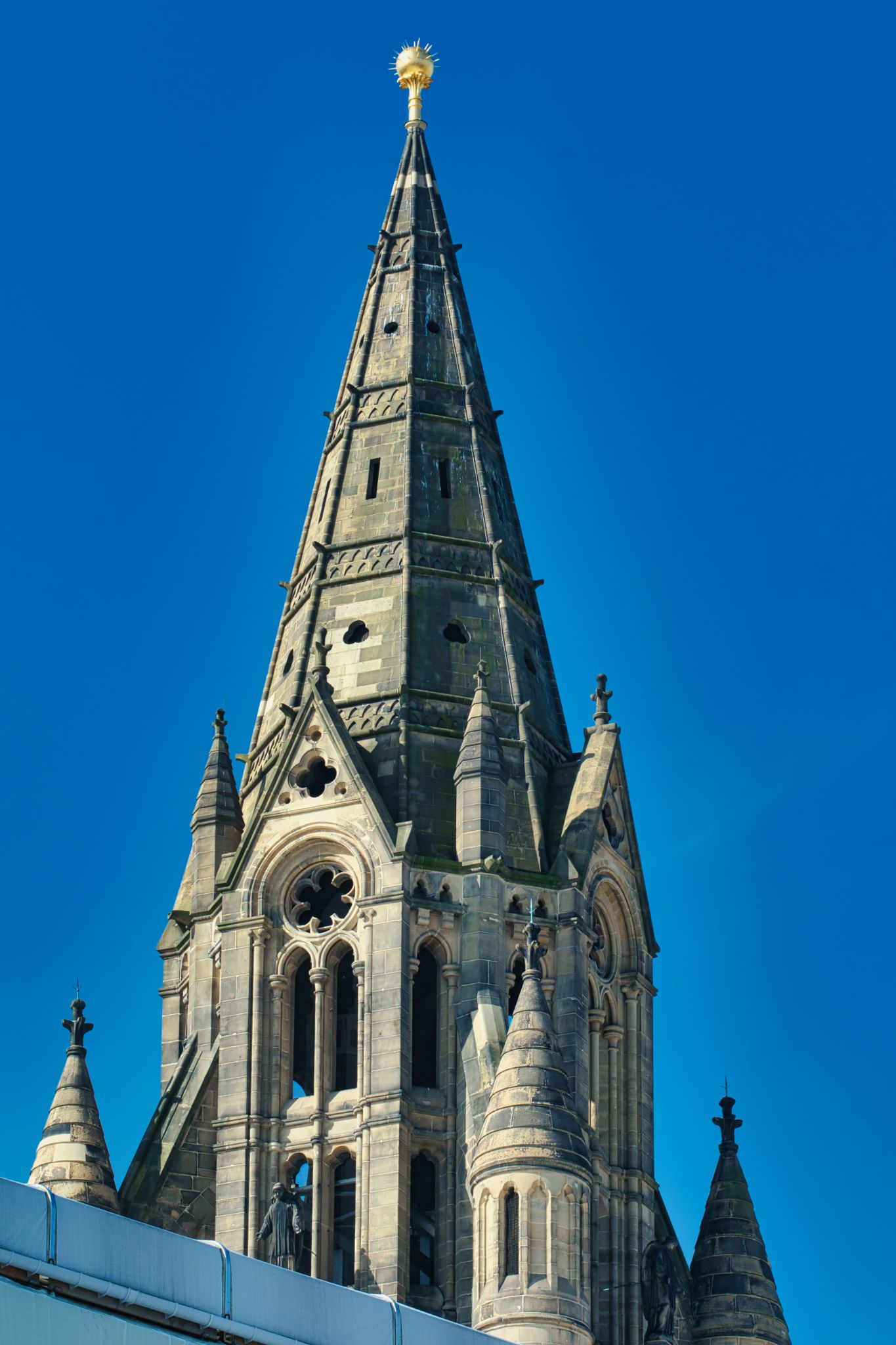 Church Spire with Golden Orb, Clear Sky in Manchester, UK.