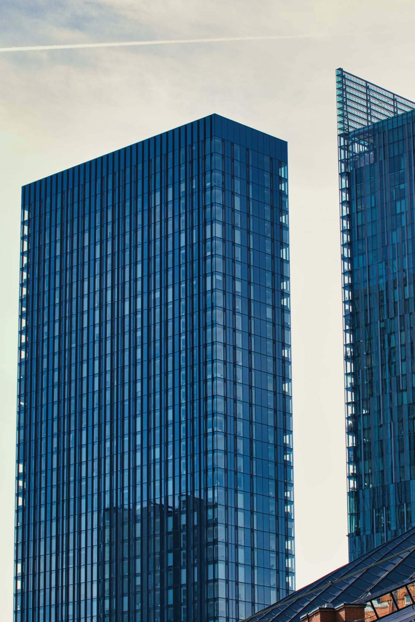 Two Blue Glass Skyscrapers Against Sky in Manchester, UK.