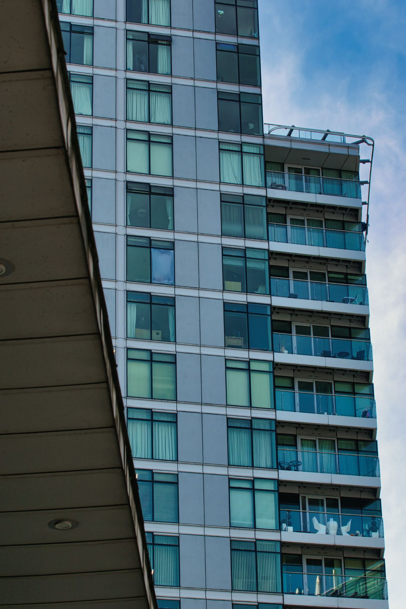 Apartment Building Facade with Balconies and Concrete Overhang in Manchester, UK.