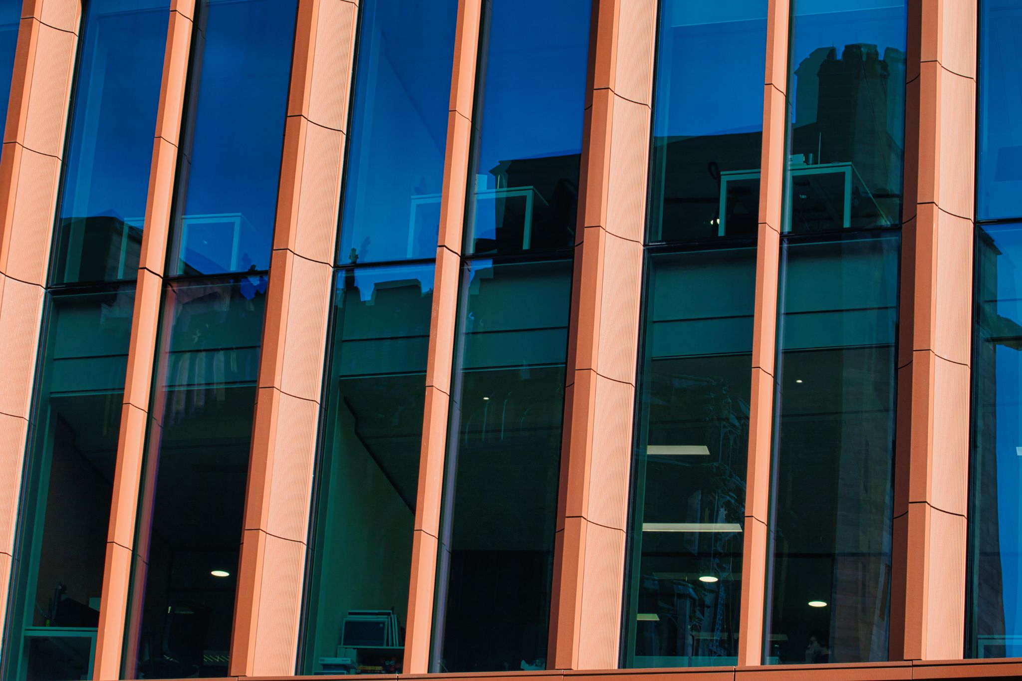 Building Facade with Blue Windows and Vertical Dividers in Manchester, UK.
