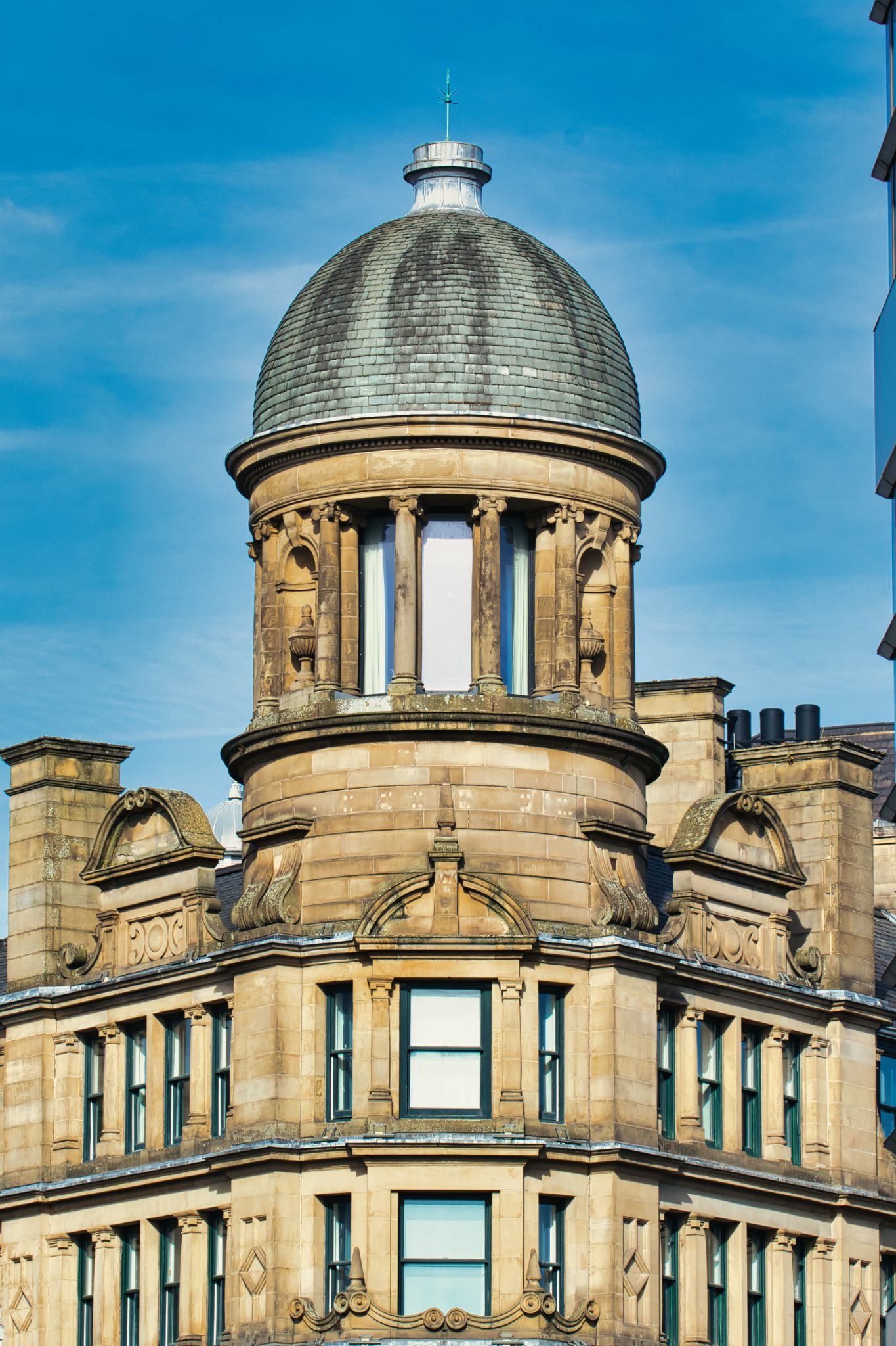 Sandstone Building with Dome Roof against Blue Sky in Manchester, UK.
