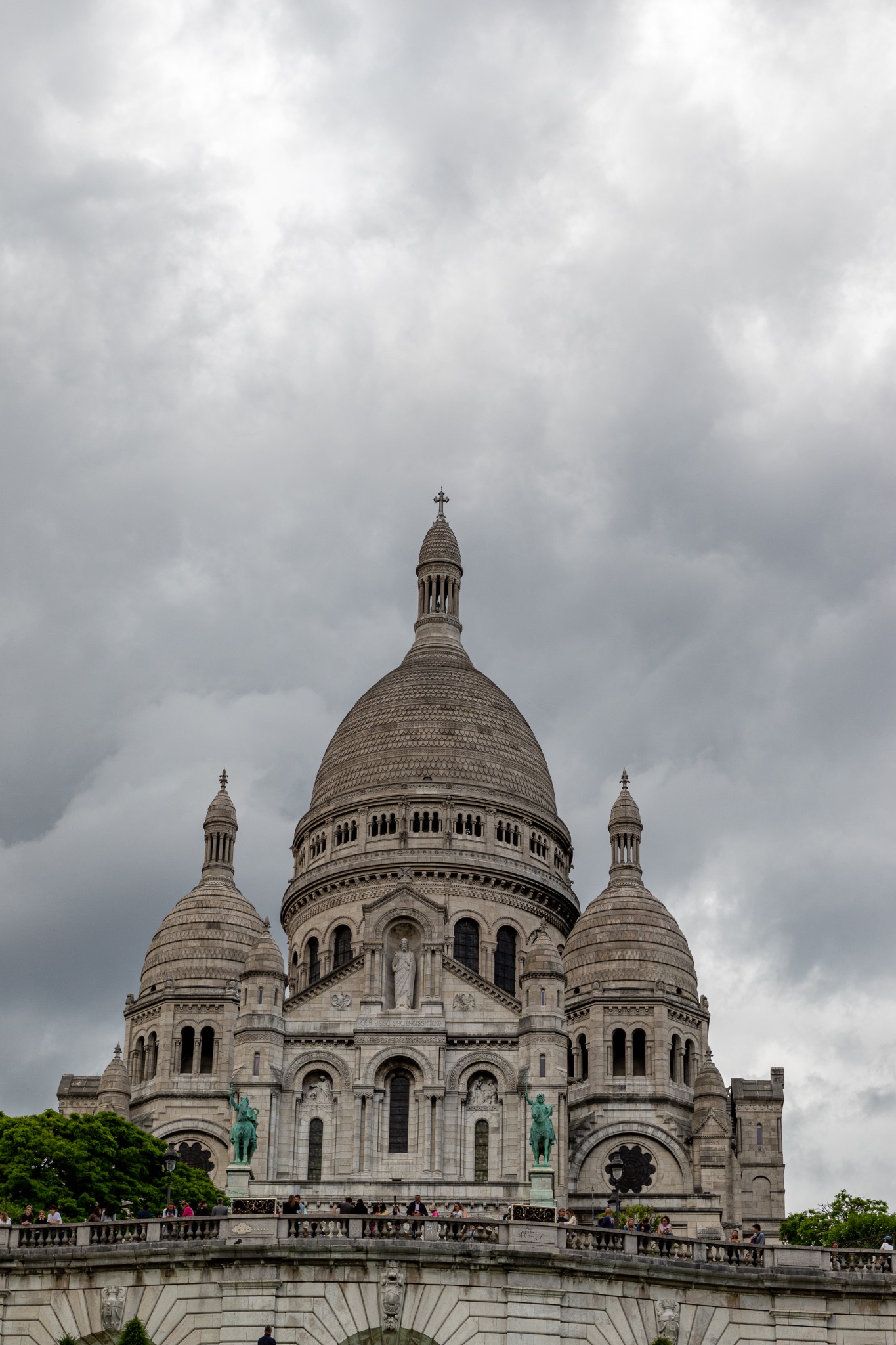 Sacre-Coeur Basilica Exterior with Cloudy Sky and People.
